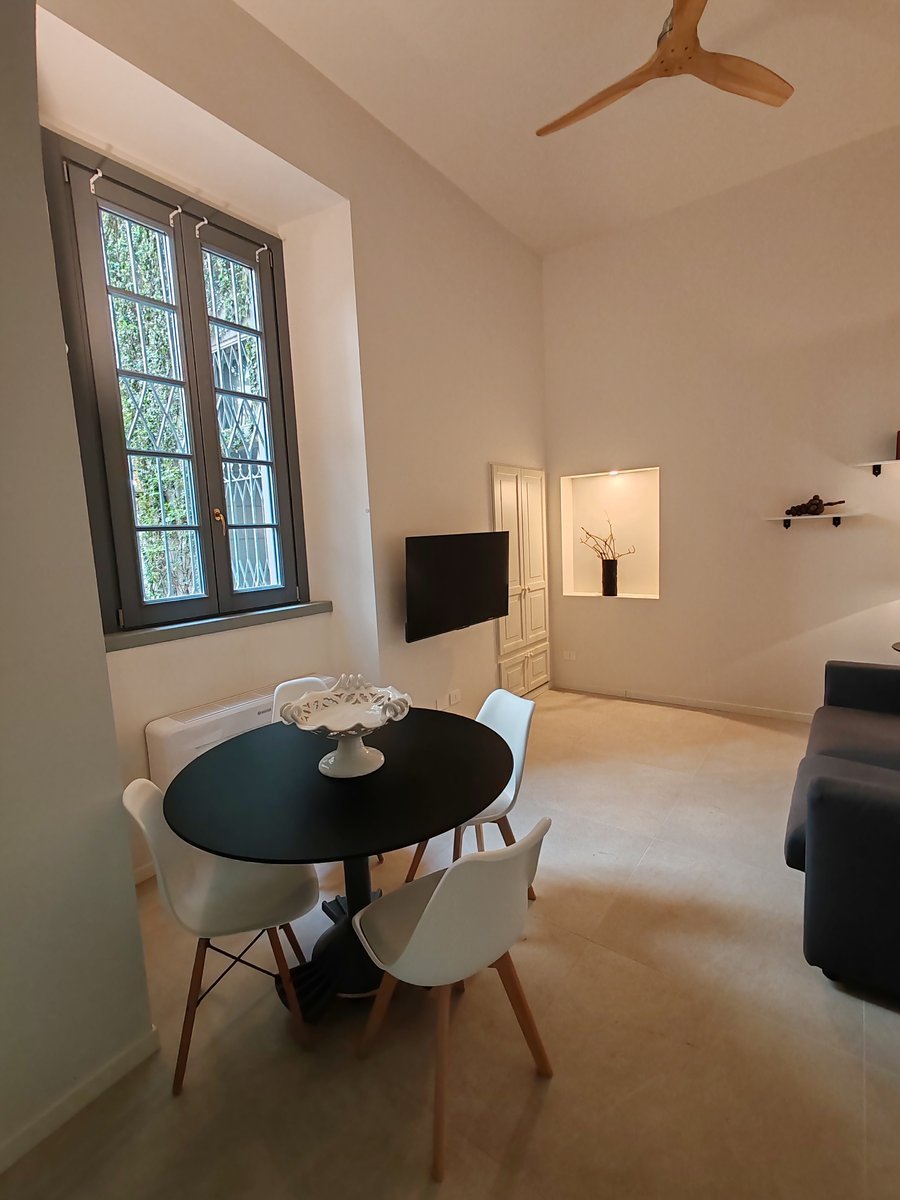 Salotto di Secret Courtyard Milano dopo la ristrutturazione, con arredi minimali e illuminazione studiata